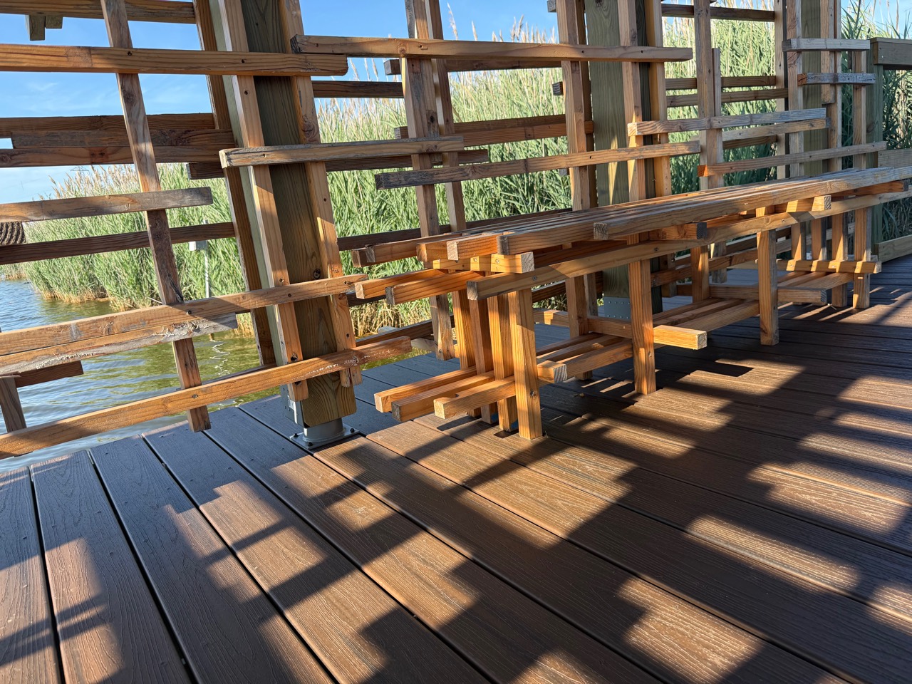 Sunlight and shadow crossing the timber interior of an open bird blind at DeKorte Park.